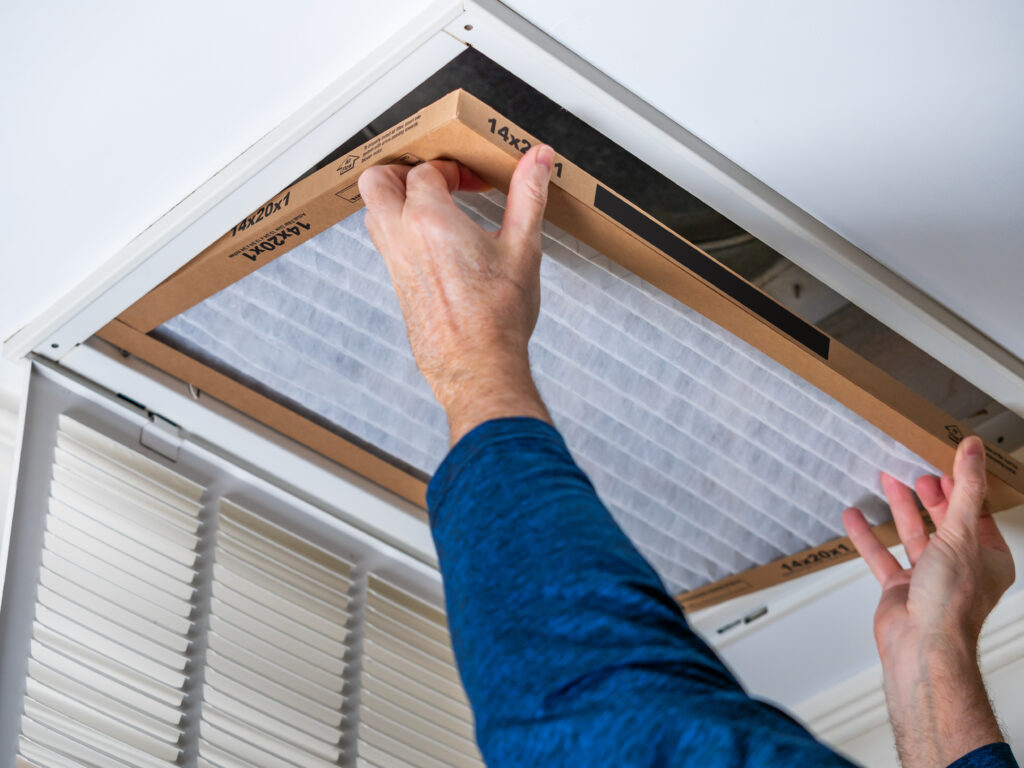 HVAC technician replacing a home air filter in Oakdale