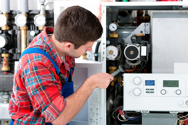 Heating technician repairing boiler controls in Oakdale