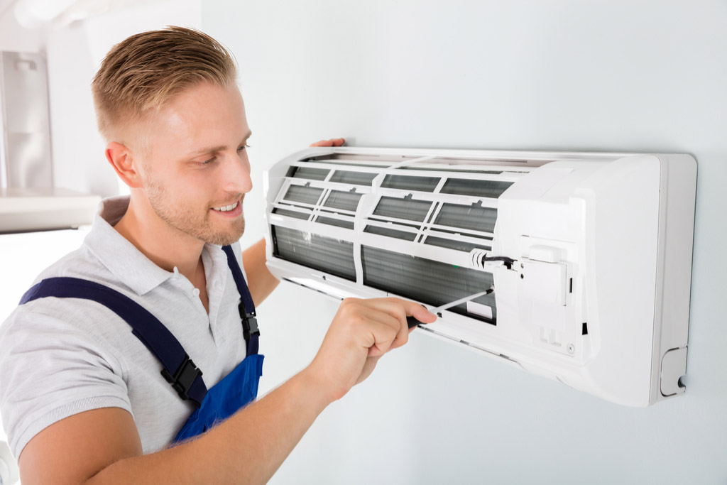 HVAC technician maintaining a ductless air conditioner in Oakdale