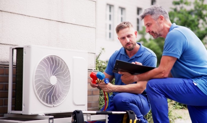 HVAC technicians installing an outdoor air conditioning unit in Oakdale